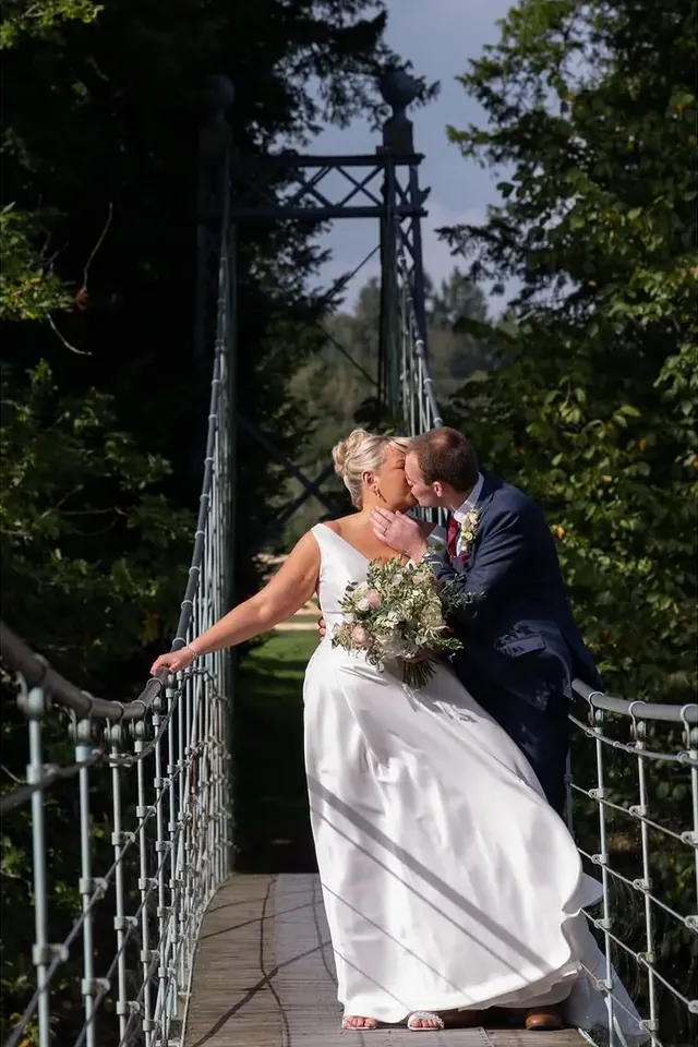 Couple kissing on a rope suspension bridge