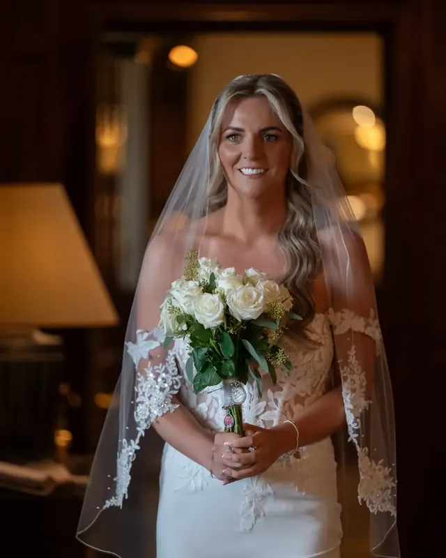 Bride holding her bouquet in a wood-panelled room