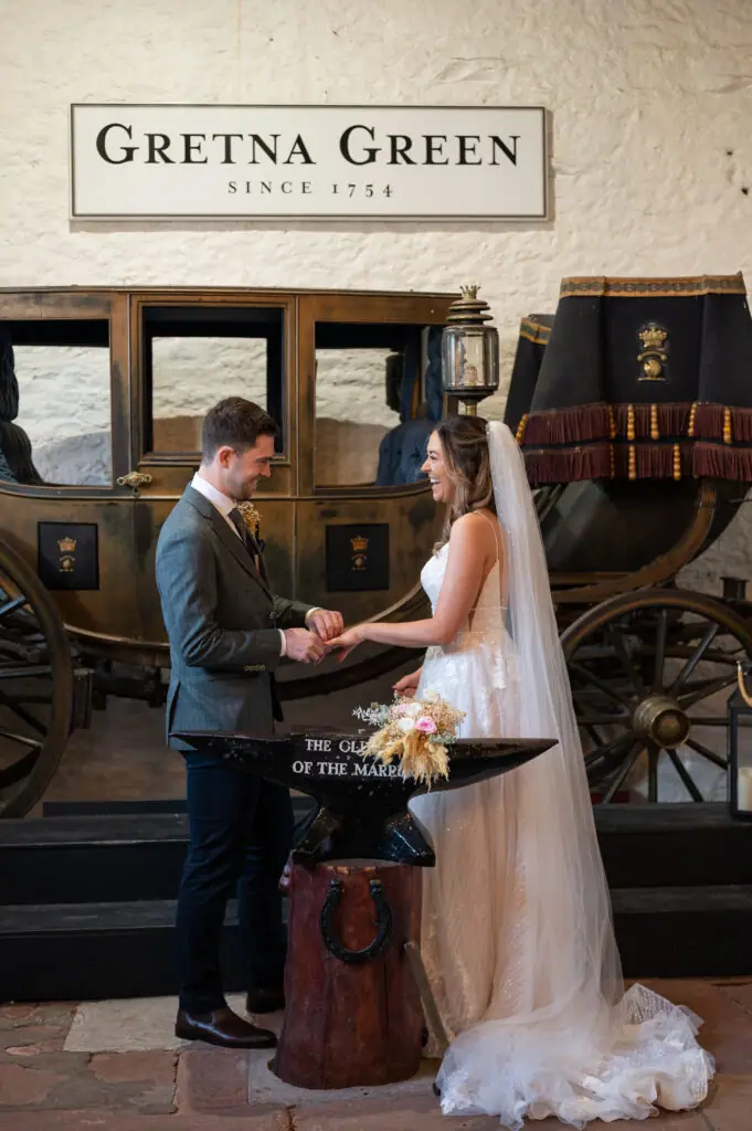Couple at the anvil in the Gretna Green blacksmith's shop