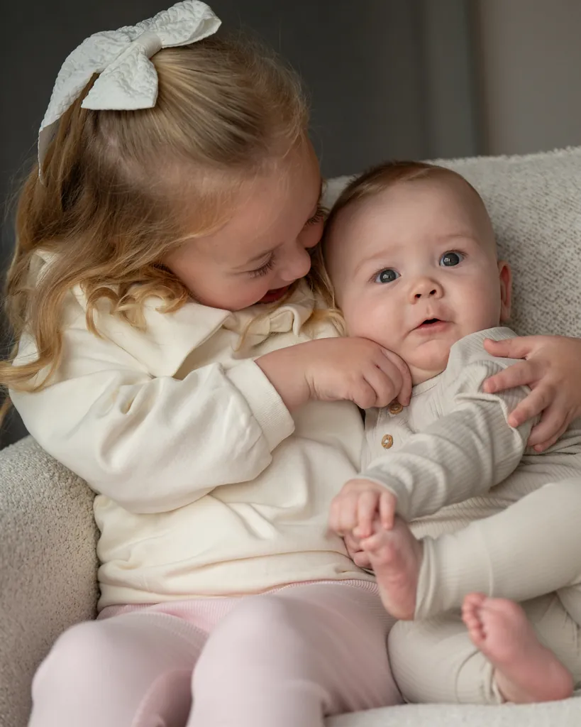 Big sister cuddling her baby sibling