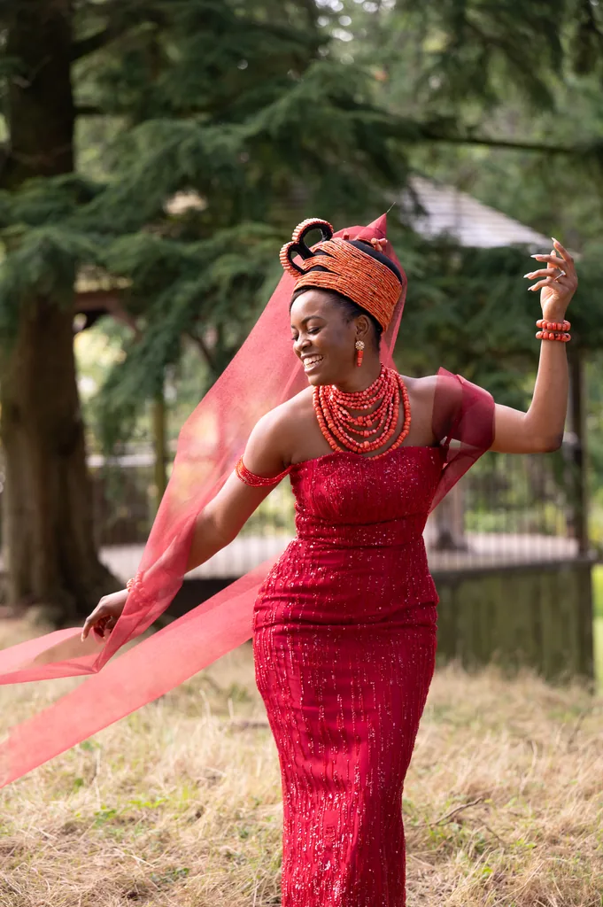Bride in a vibrant red traditional gown and headpiece posing outdoors