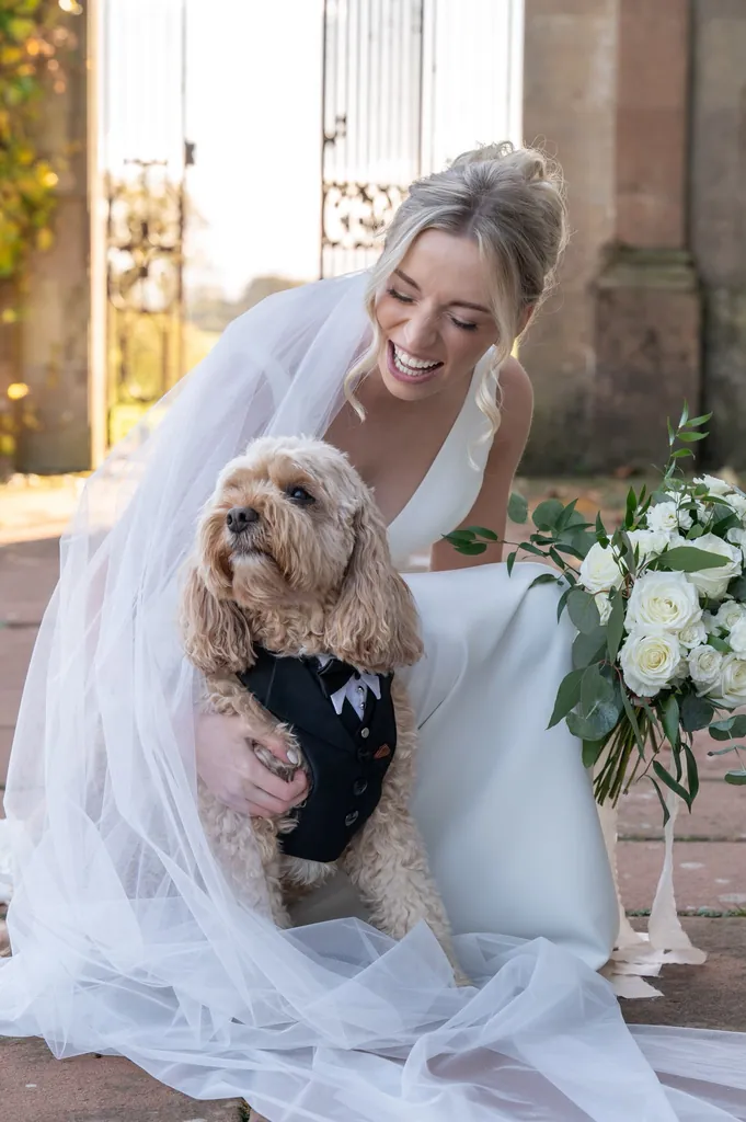 Bride in her wedding dress holding her cockapoo