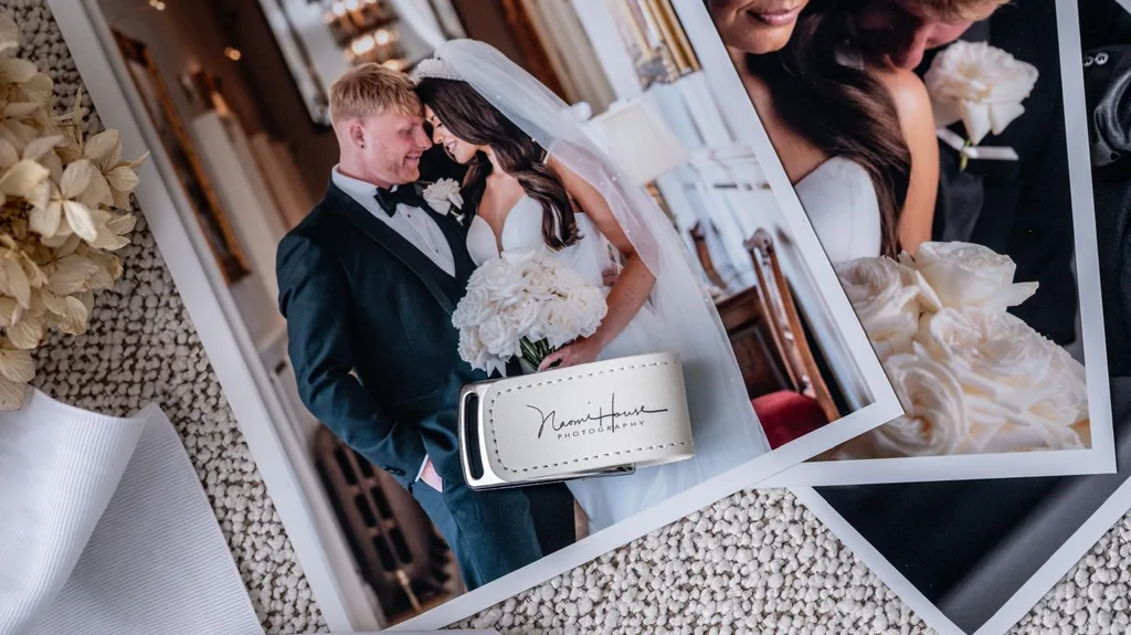 Naomi House Photography branded USB memory stick resting on printed wedding photographs with dried flowers